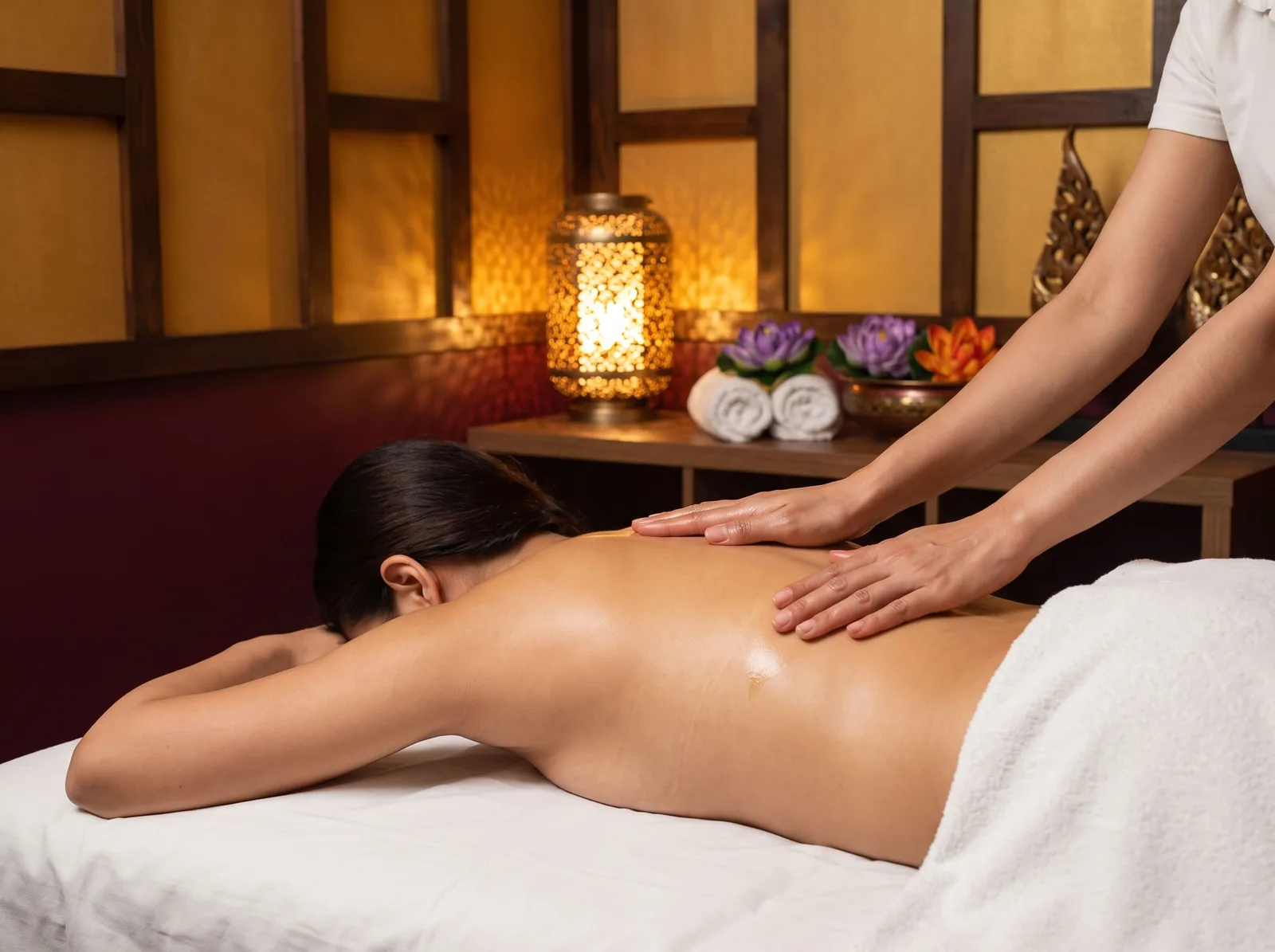 Klassische Massage bei BANN Thaimassage in Basel Klassische Massage in Basel: Hände einer Masseurin verteilen warmes Öl auf dem Rücken